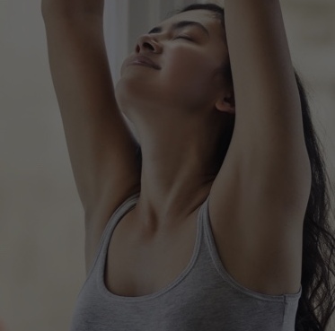 Woman stretching arms up by an open window