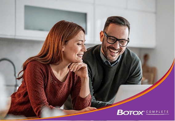 A man and a woman reading in a kitchen